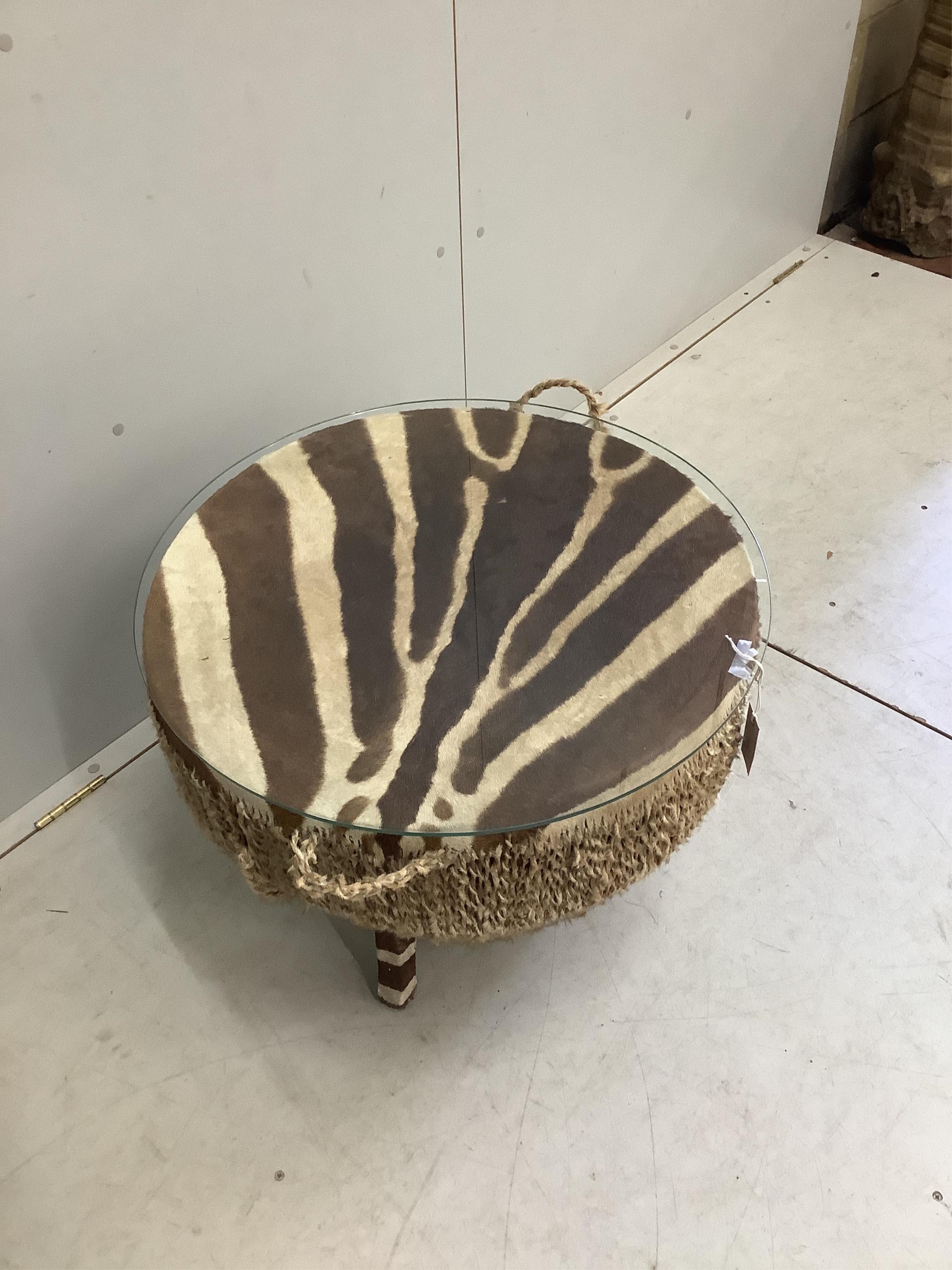 An African zebra skin drum, now as a glass top occasional table, diameter 62cm, height 51cm. Condition - fair